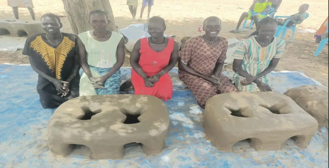 Members of a women’s production group with completed fuel-efficient stoves.