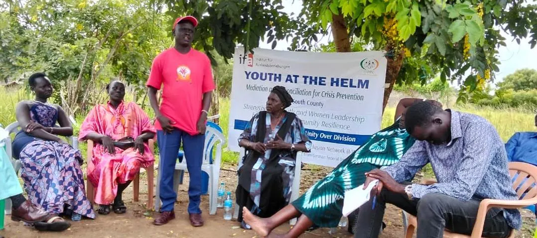 Women and men share ideas during a community consultation.